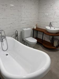 a bathroom with a sink and a tub and a toilet at Brewery House&Beer Spa in Aspindza