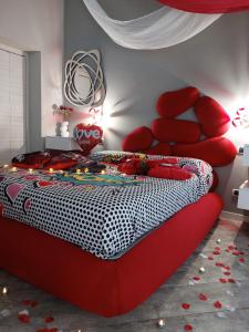 una camera con un letto rosso e una sedia rossa di BELLAVISTA EXCLUSIVE B&B VISTA LAGO Piscina riscaldata e Jacuzzi a Desenzano del Garda