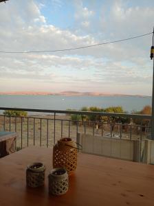 un tavolo con tre vasi su un balcone con vista sull'oceano di Seaside resort / Lemnos 