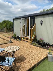 a small house with a table and a patio at Close to Nature Easy to Find shepherd's hut in North Molton