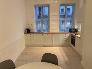 a kitchen with white cabinets and a table and chairs at City Center Apartments 870 in Copenhagen