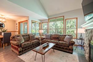 a living room with two couches and a table at Arrowhead Point by Outpost Whistler in Whistler