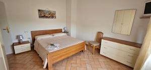 a bedroom with a bed and a cabinet and a chair at Delizioso appartamento collinare in Limigiano