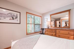 a bedroom with a bed and a large mirror at Arrowhead Point by Outpost Whistler in Whistler