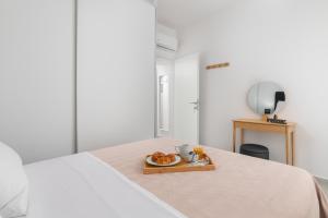 a tray with a plate of food on a bed at Rhodes city studios in Rhodes Town