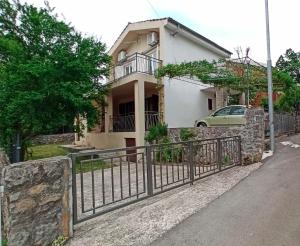a house with a fence in front of it at Holiday Home Family - 100m from sea in Vantačići
