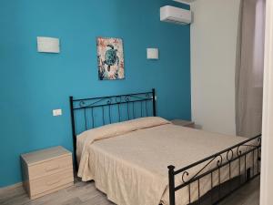 Dormitorio azul con cama y pared azul en Rooms da Pisicchio, en Fiumicino