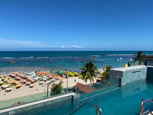 uma vista para uma praia com uma piscina em Flat mar Porto de Galinhas em Porto de Galinhas