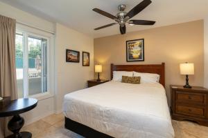 a bedroom with a bed and a ceiling fan at 2 Bedroom Kapaa Condo, Pool, AC, Beach Access KK116 in Kapaa +25 photos