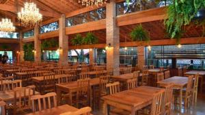 un restaurant vide avec des tables et des chaises en bois dans l'établissement Santana's Ranch, à São Pedro