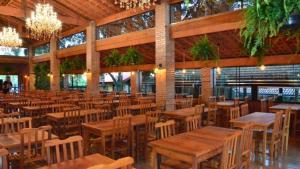 an empty restaurant with wooden tables and chairs at Santana's Ranch in São Pedro
