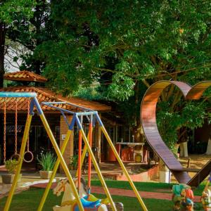 a playground with a slide in front of a house at Santana's Ranch in São Pedro