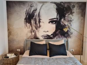ein Schlafzimmer mit einem großen Gemälde über einem Bett in der Unterkunft Apartament 221 Mamaia Nord in Mamaia Nord – Năvodari