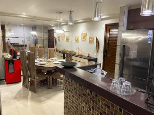 a large kitchen with a table and a refrigerator at Charmoso apto em Barra Bali - Destino BSM 108 in Barra de São Miguel