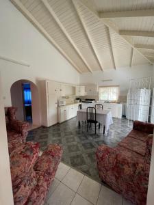 a living room with a table and chairs and a kitchen at Thomas Apartment Inc in Kingstown