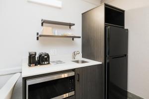 a small kitchen with a sink and a refrigerator at Studio 6 Baytown, Tx - Garth Road in Baytown