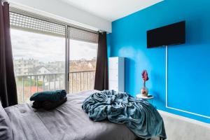 薩特魯維爾的住宿－Le cocon - DGI，一间卧室配有一张蓝色墙壁的床