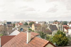 薩特魯維爾的住宿－Le cocon - DGI，享有带房屋和屋顶的城市美景