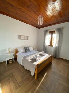 a bedroom with a large bed and a wooden ceiling at Vasileris Home in Moúdhros