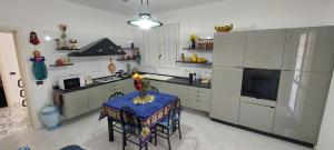 a kitchen with a table and a stove and a refrigerator at La Villetta di Sabrina in Marsala