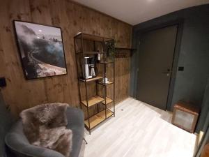 a living room with a chair and a book shelf at Fossheim Lodge Nr 10 in Torset