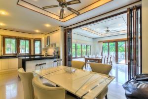 プーケットタウンにあるSpacious villa with private garden by CapitalProのテーブルと椅子のあるキッチンとダイニングルーム