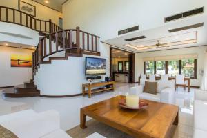 プーケットタウンにあるSpacious villa with private garden by CapitalProのリビングルーム(階段、テーブル付)