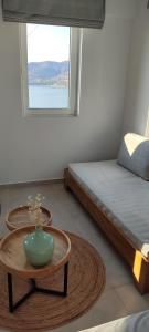 a room with a bed and a table with a vase on it at Theasis Limnos - 1st floor suite in Agios Ioannis Kaspaka