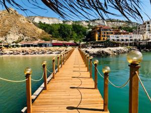 a wooden bridge over the water next to a beach at Apartment 9 in Balchik
