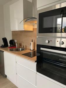 a kitchen with a microwave oven and a sink at Nid Douillet in Saint-Paul-lès-Dax