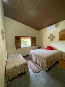 1 dormitorio con 2 camas y ventana en Casa do sossego en Jijoca de Jericoacoara