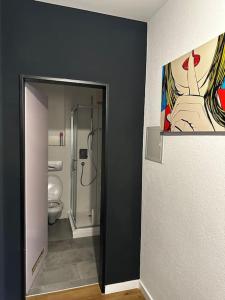 a bathroom with a toilet and a painting on the wall at Coole Wohnung + Gratis Parkplatz in Schwäbisch Hall