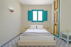 a bedroom with a large bed with blue accents at Nissia Beach Apartments & Suites in Kamari