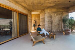 a woman sitting on a porch reading a book at Paradero Todos Santos - Exclusive experiences included in Todos Santos