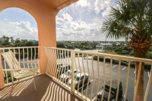 a balcony with a palm tree and a view of a street at Creston House 6E in St. Augustine