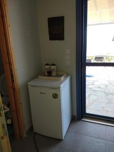 a small white refrigerator in a room with a window at Seaside resort / Lemnos 