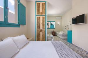 a bedroom with a bed and a bathroom with a tub at Nissia Beach Apartments & Suites in Kamari