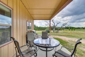 um alpendre coberto com uma mesa de vidro e cadeiras em Bertram Ranch Property with Acreage and Trail Access! em Bertram