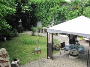 a white tent in a garden with a table at Kiki's B&B in Basel