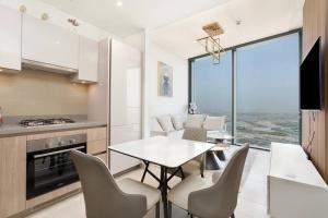 een keuken en eetkamer met een tafel en stoelen bij Modern 1bdr - 10min from Burj Khalifa - Sobha Waves in Dubai