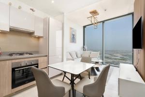 une cuisine et une salle à manger avec une table et des chaises dans l'établissement Modern 1bdr - 10min from Burj Khalifa - Sobha Waves, à Dubaï