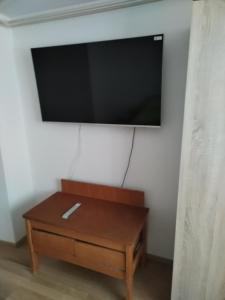 a flat screen tv hanging on a wall above a coffee table at Apartment Jalen in Bohinjska Bela