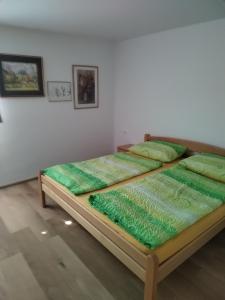 2 camas en una habitación con cojines verdes en Apartment Jalen, en Bohinjska Bela