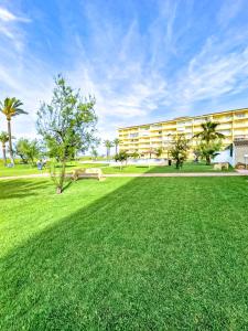 a park with a large building and a grass field at Apartamento Primera Línea Marines Racons, Les Deveses, Denia in Casas Devesa +41 photos
