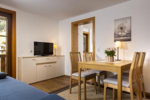 Sala de estar con mesa de comedor y TV en Haus Arnika en Sankt Jakob in Defereggen