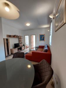 a living room with a red couch and a table at Apartments Maris in Vranjic