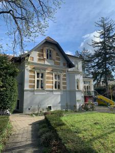 een groot wit huis met een boom bij Haus HaWei in Wenen