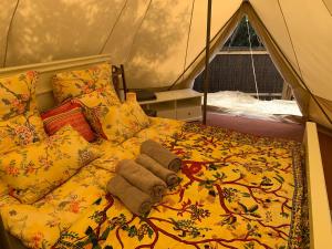 Una cama en una tienda con toallas. en Eco Glamping. Private luxury tent in Alfambras., en Aljezur