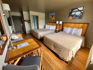 a hotel room with two beds and a table and a desk at Rocker Inn in Butte +28 photos