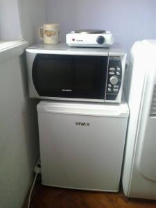 un forno a microonde seduto sopra un frigorifero di Ana a Spalato (Split)